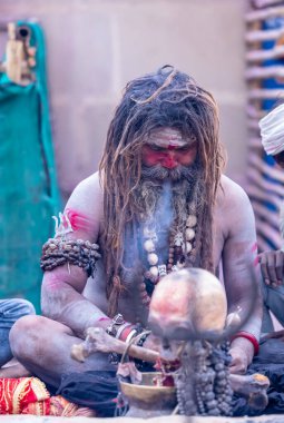 Varanasi, Uttar Pradesh, Hindistan - 21 Mart 2024: Masan Holi, Harishchandra ghat 'ta düzenlenen the Varanasi Holi festivali sırasında kimliği belirsiz bir erkek ağustos sadhu portresi.
