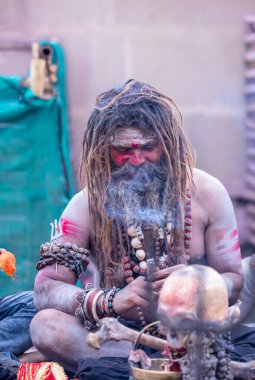 Varanasi, Uttar Pradesh, Hindistan - 21 Mart 2024: Masan Holi, Harishchandra ghat 'ta düzenlenen the Varanasi Holi festivali sırasında kimliği belirsiz bir erkek ağustos sadhu portresi.