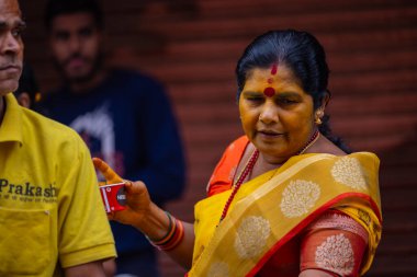 Varanasi, Uttar Pradesh, Hindistan - 21 Mart 2024: Varanasi kışlasının sokaklarında dikilen kimliği belirsiz Hintli bir kadının portresi Lord Shiv 'in darshan' ını aldı.