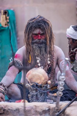 Varanasi, Uttar Pradesh, Hindistan - 21 Mart 2024: Masan Holi, Harishchandra ghat 'ta düzenlenen the Varanasi Holi festivali sırasında kimliği belirsiz bir erkek ağustos sadhu portresi.