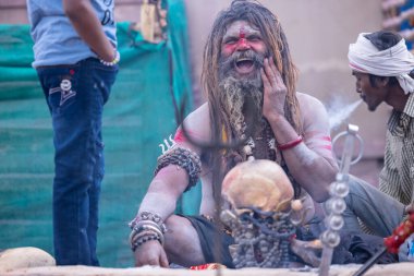 Varanasi, Uttar Pradesh, Hindistan - 21 Mart 2024: Masan Holi, Harishchandra ghat 'ta düzenlenen the Varanasi Holi festivali sırasında kimliği belirsiz bir erkek ağustos sadhu portresi.
