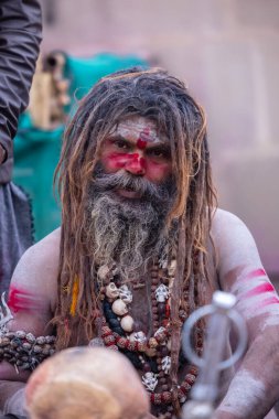 Varanasi, Uttar Pradesh, Hindistan - 21 Mart 2024: Masan Holi, Harishchandra ghat 'ta düzenlenen the Varanasi Holi festivali sırasında kimliği belirsiz bir erkek ağustos sadhu portresi.