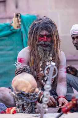 Varanasi, Uttar Pradesh, Hindistan - 21 Mart 2024: Masan Holi, Harishchandra ghat 'ta düzenlenen the Varanasi Holi festivali sırasında kimliği belirsiz bir erkek ağustos sadhu portresi.