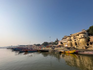 Varanasi, Uttar Pradesh, Hindistan - 17 Kasım 2022: Varanasi 'deki nehir çetelerinin yakınlarındaki ghatların mimari görüşü ve tapınakları. Ganga nehrinde yüzen tekneden binaların görüntüsü.