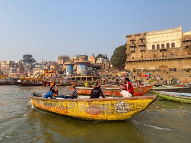 Varanasi, Uttar Pradesh, Hindistan - 17 Kasım 2022: Varanasi 'deki nehir çetelerinin yakınlarındaki ghatların mimari görüşü ve tapınakları. Ganga nehrinde yüzen tekneden binaların görüntüsü.