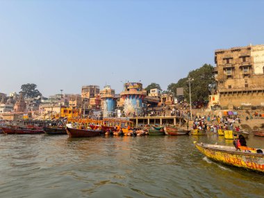 Varanasi, Uttar Pradesh, Hindistan - 17 Kasım 2022: Varanasi 'deki nehir çetelerinin yakınlarındaki ghatların mimari görüşü ve tapınakları. Ganga nehrinde yüzen tekneden binaların görüntüsü.