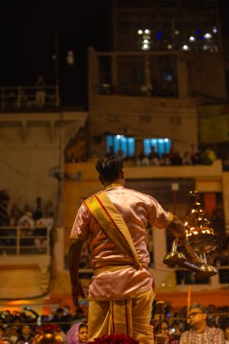 Varanasi, Uttar Pradesh, Hindistan - 20 Mart 2024: Ganga aarti, genç erkek rahip dashashwamedh ghat geleneksel elbise ve hindu ritüelleri ile kutsal nehir kenevir akşam aarti performans.