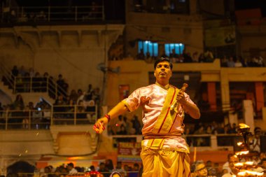 Varanasi, Uttar Pradesh, Hindistan - 20 Mart 2024: Ganga aarti, genç erkek rahip dashashwamedh ghat geleneksel elbise ve hindu ritüelleri ile kutsal nehir kenevir akşam aarti performans.