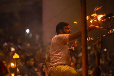 Varanasi, Uttar Pradesh, Hindistan - 20 Mart 2024: Ganga aarti, genç erkek rahip dashashwamedh ghat geleneksel elbise ve hindu ritüelleri ile kutsal nehir kenevir akşam aarti performans.