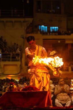 Varanasi, Uttar Pradesh, Hindistan - 20 Mart 2024: Ganga aarti, genç erkek rahip dashashwamedh ghat geleneksel elbise ve hindu ritüelleri ile kutsal nehir kenevir akşam aarti performans.