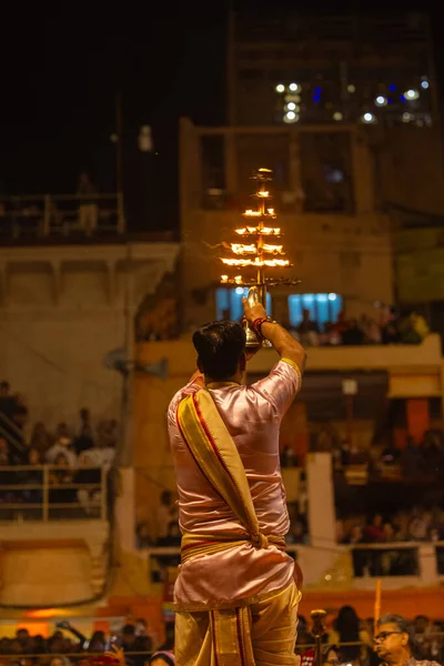 Varanasi, Uttar Pradesh, Hindistan - 20 Mart 2024: Ganga aarti, genç erkek rahip dashashwamedh ghat geleneksel elbise ve hindu ritüelleri ile kutsal nehir kenevir akşam aarti performans.
