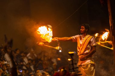 Varanasi, Uttar Pradesh, Hindistan - 20 Mart 2024: Ganga aarti, genç erkek rahip dashashwamedh ghat geleneksel elbise ve hindu ritüelleri ile kutsal nehir kenevir akşam aarti performans.