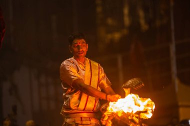 Varanasi, Uttar Pradesh, Hindistan - 20 Mart 2024: Ganga aarti, genç erkek rahip dashashwamedh ghat geleneksel elbise ve hindu ritüelleri ile kutsal nehir kenevir akşam aarti performans.