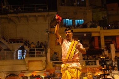 Varanasi, Uttar Pradesh, Hindistan - 20 Mart 2024: Ganga aarti, genç erkek rahip dashashwamedh ghat geleneksel elbise ve hindu ritüelleri ile kutsal nehir kenevir akşam aarti performans.