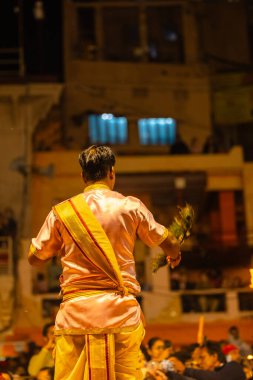Varanasi, Uttar Pradesh, Hindistan - 20 Mart 2024: Ganga aarti, genç erkek rahip dashashwamedh ghat geleneksel elbise ve hindu ritüelleri ile kutsal nehir kenevir akşam aarti performans.