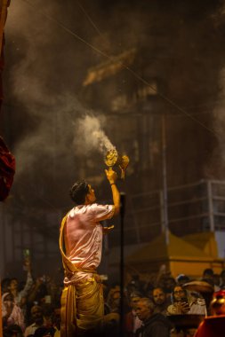 Varanasi, Uttar Pradesh, Hindistan - 20 Mart 2024: Ganga aarti, genç erkek rahip dashashwamedh ghat geleneksel elbise ve hindu ritüelleri ile kutsal nehir kenevir akşam aarti performans.