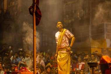 Varanasi, Uttar Pradesh, Hindistan - 20 Mart 2024: Ganga aarti, genç erkek rahip dashashwamedh ghat geleneksel elbise ve hindu ritüelleri ile kutsal nehir kenevir akşam aarti performans.