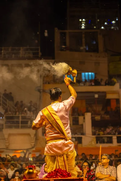 Varanasi, Uttar Pradesh, Hindistan - 20 Mart 2024: Ganga aarti, genç erkek rahip dashashwamedh ghat geleneksel elbise ve hindu ritüelleri ile kutsal nehir kenevir akşam aarti performans.
