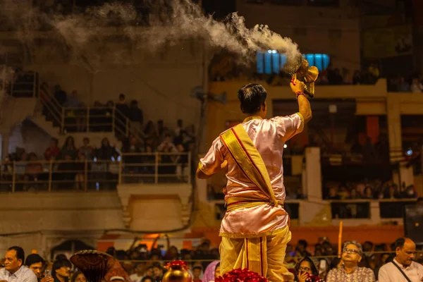 Varanasi, Uttar Pradesh, Hindistan - 20 Mart 2024: Ganga aarti, genç erkek rahip dashashwamedh ghat geleneksel elbise ve hindu ritüelleri ile kutsal nehir kenevir akşam aarti performans.