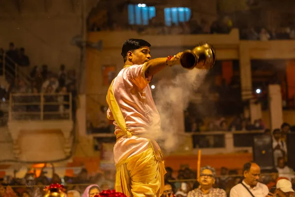 Varanasi, Uttar Pradesh, Hindistan - 20 Mart 2024: Ganga aarti, genç erkek rahip dashashwamedh ghat geleneksel elbise ve hindu ritüelleri ile kutsal nehir kenevir akşam aarti performans.