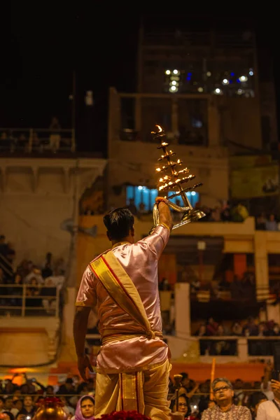Varanasi, Uttar Pradesh, Hindistan - 20 Mart 2024: Ganga aarti, genç erkek rahip dashashwamedh ghat geleneksel elbise ve hindu ritüelleri ile kutsal nehir kenevir akşam aarti performans.