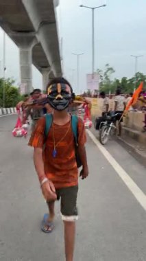Gaziabad, Uttar Pradesh, Hindistan - 24 Temmuz 2025: Hindu dindarının maha shivratri festivali sırasında kutsal Ganga suyu ve Lord Shiv putu taşıyarak çıplak ayakla kanwar yatra performansı videosu.