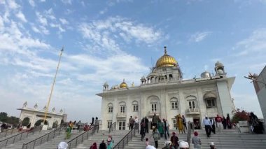 Yeni Delhi, Hindistan - 28 Şubat 2025: Delhi 'deki Sri bangla sahib gurudwara' nın mimari görüşü ve çevresindeki ibadete düşkün kişiler. İnşa ederken, altın kubbe, Sikh ibadet ederken, inançlı dua ederken.