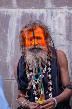 Varanasi, Uttar Pradesh, India - March 21, 2024: Masan Holi, Portrait of an unidentified aghori sadhu smoking and performing rituals during masan holi festival in varanasi at harishchandra ghat.