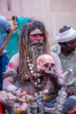Varanasi, Uttar Pradesh, India - March 21, 2024: Masan Holi, Portrait of an unidentified aghori sadhu smoking and performing rituals during masan holi festival in varanasi at harishchandra ghat.
