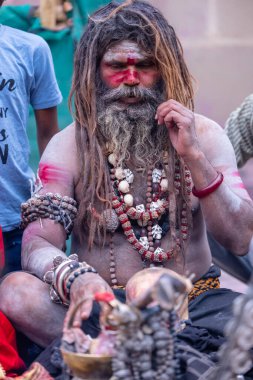 Varanasi, Uttar Pradesh, India - March 21, 2024: Masan Holi, Portrait of an unidentified aghori sadhu smoking and performing rituals during masan holi festival in varanasi at harishchandra ghat.