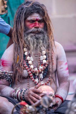 Varanasi, Uttar Pradesh, India - March 21, 2024: Masan Holi, Portrait of an unidentified aghori sadhu smoking and performing rituals during masan holi festival in varanasi at harishchandra ghat.