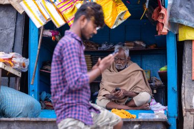 Prayagraj, Uttar Pradesh, Hindistan - 15 Ocak 2025: Mahakumbh, Kimliği belirsiz bir erkek sokak satıcısının portresi, kumbh mela 'nın kış sabahı çayhanesinde ürün satışı