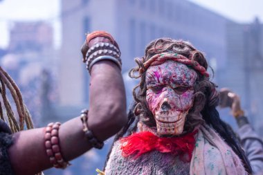 Varanasi, Uttar Pradesh, India - March 20, 2024: Masan Holi, Portrait of an male devotee with painted face with dry ash dressed as lord shiva during the celebration of masan holi at harishchandra ghat.