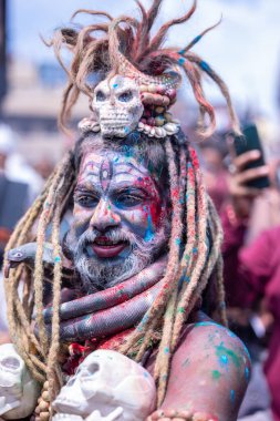 Varanasi, Uttar Pradesh, India - March 20, 2024: Masan Holi, Portrait of an male devotee with painted face with dry ash dressed as lord shiva during the celebration of masan holi at harishchandra ghat.