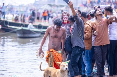 Varanasi, Uttar Pradesh, India - March 21, 2024: Masan Holi, Masan Holi, Group of unidentified devotees participating in masan holi festival at manikarnika ghat of varanasi with colours.