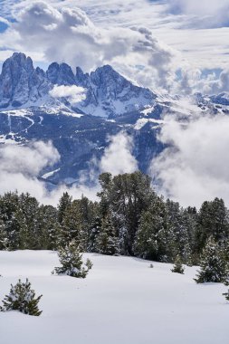 Güneşli bir kış gününde bulutların içindeki dağların manzarası