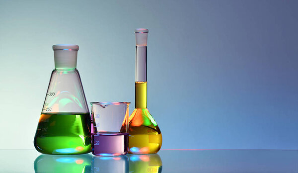 Laboratory glassware with colorful liquids and chemicals on blue background