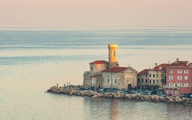 Sabah erken güneş tarafından Piran, Slovenya, deniz feneri yaktı