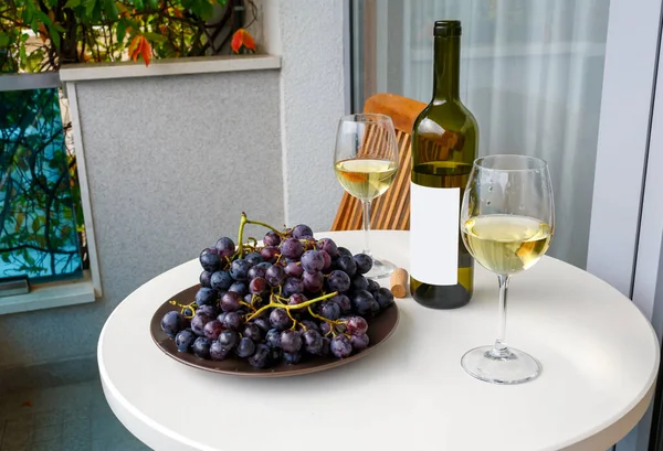 Şarap şişesi ve meyve masada.