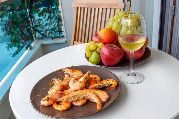 Şarap şişesi ve meyve masada.