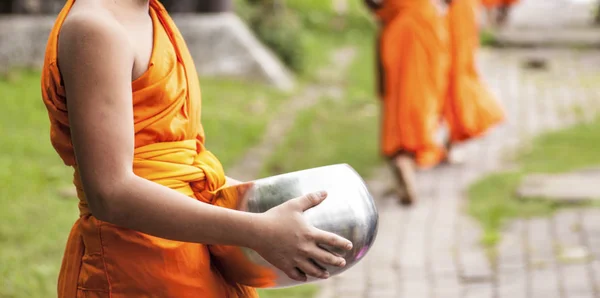 年轻的佛教僧侣在他们的早晨游行 在一个摩门手附近提供食物 — 图库照片