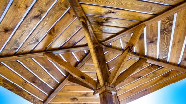  Sahilde mavi arka planda bir güneş şemsiyesi. Masmavi güneşli gökyüzüne karşı ahşap plaj şemsiyeleri