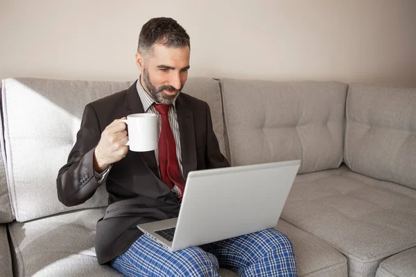 スーツを着て家で働くビジネスマンとコーヒーを飲みながらパジャマパンツ — ストック写真