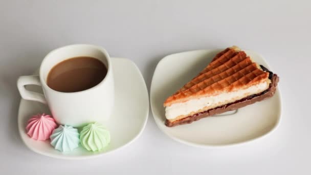 Maränger, tårta, sötsaker och en kopp kaffe på en vit bakgrund. God morgon.. — Stockvideo