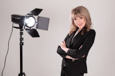 Profesyonel ekipmanlı stüdyoda güzel bir model poz veriyor. Fotoğraf stüdyosunda lambalı bir iş kadını.