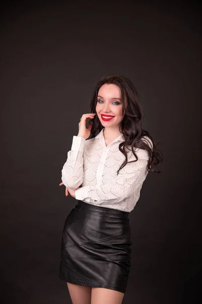 Portrait of a business woman, happy and smiling as she looks at the camera. black background. Concept of: success, finance and female career