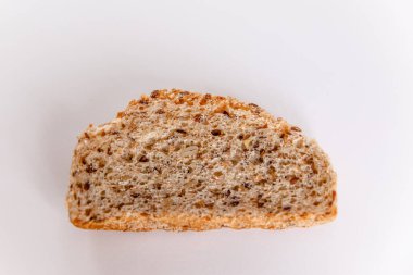 Beyaz arka planda mısır gevreği olan bir parça yararlı ekmek.