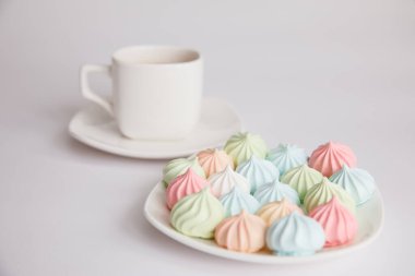 İyi sabahlar. İzole edilmiş beyaz bir arka planda bir fincan çay tabağında krema ve bir fincan kahve. Kahve kültürü