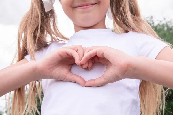 Liten Flicka Ler Och Visar Ett Hjärttecken Med Händerna Barn — Stockfoto