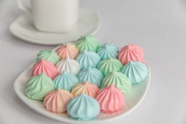 İyi sabahlar. İzole edilmiş beyaz bir arka planda bir fincan çay tabağında krema ve bir fincan kahve. Kahve kültürü